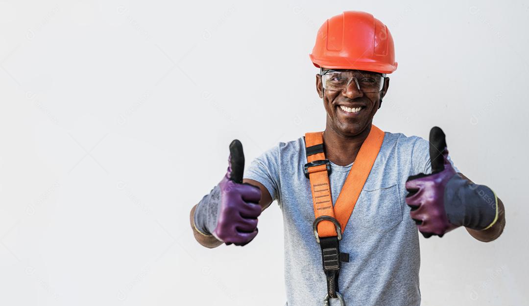 Confiante jovem carpinteiro latino masculino olhando para a câmera com sorriso em pé contra um fundo branco