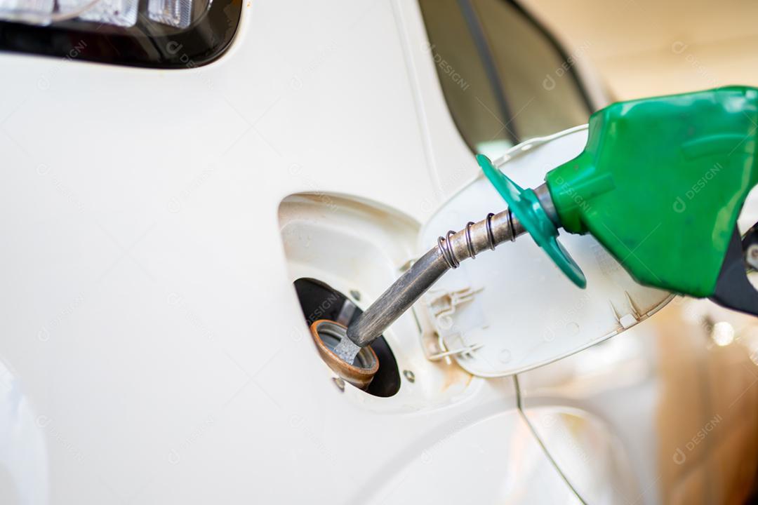 Aproximação do homem bombeando gasolina no carro no posto de gasolina