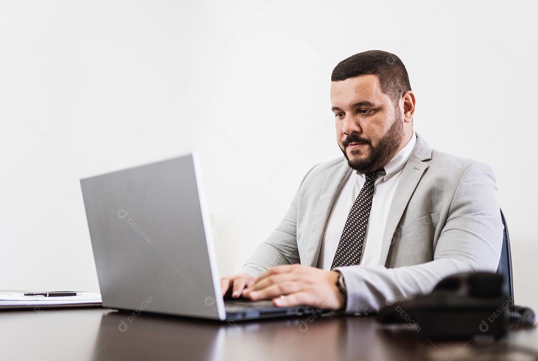 Businessman working in office with laptop and documents