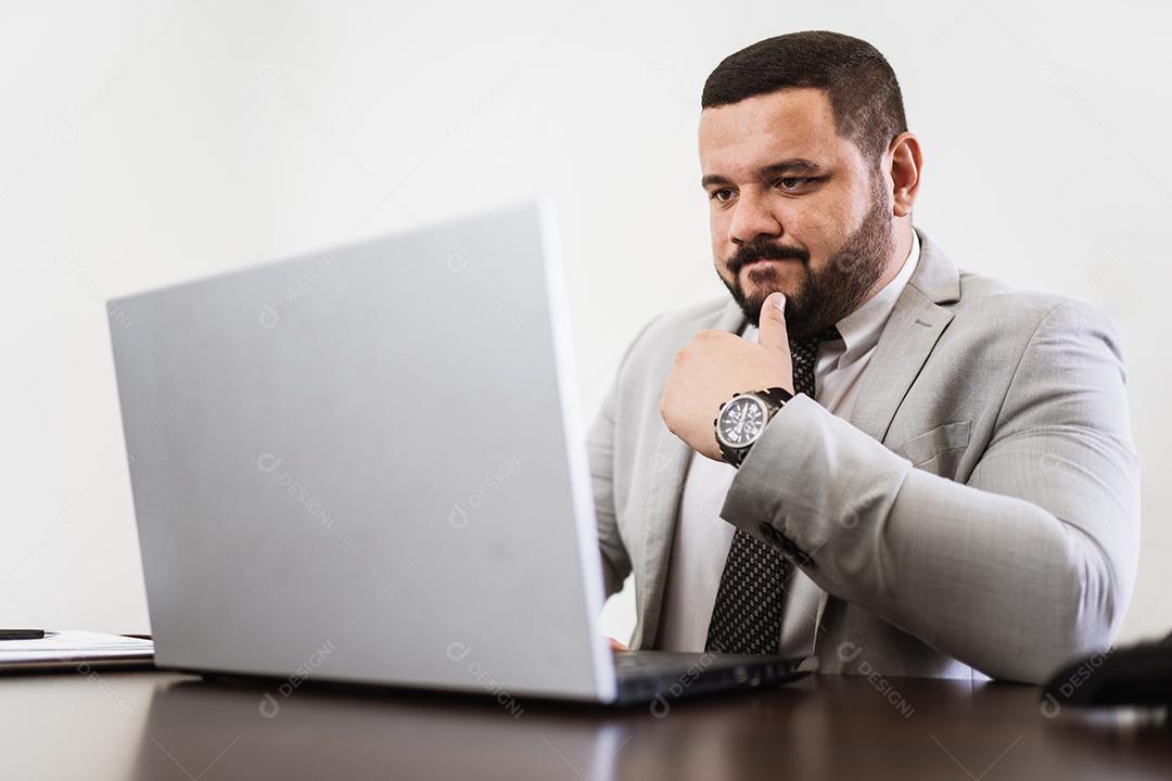 Empresário trabalhando no escritório com laptop e documentos