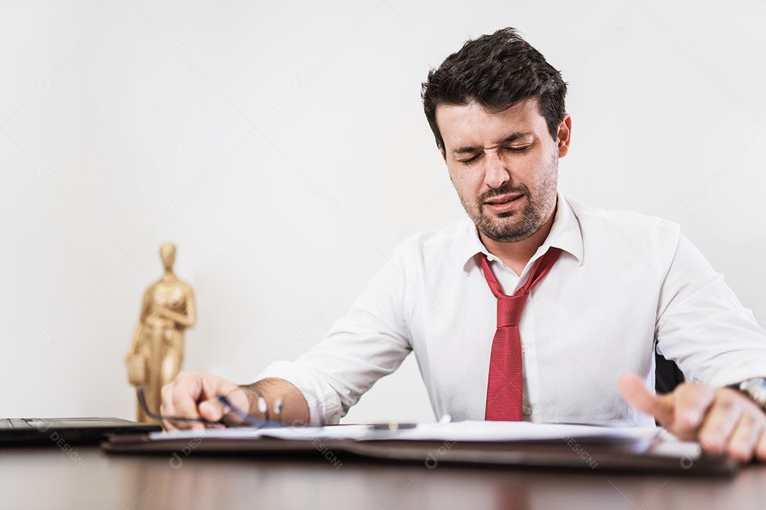 Jovem advogado latino ou empregado trabalhando à noite no escritório estressado