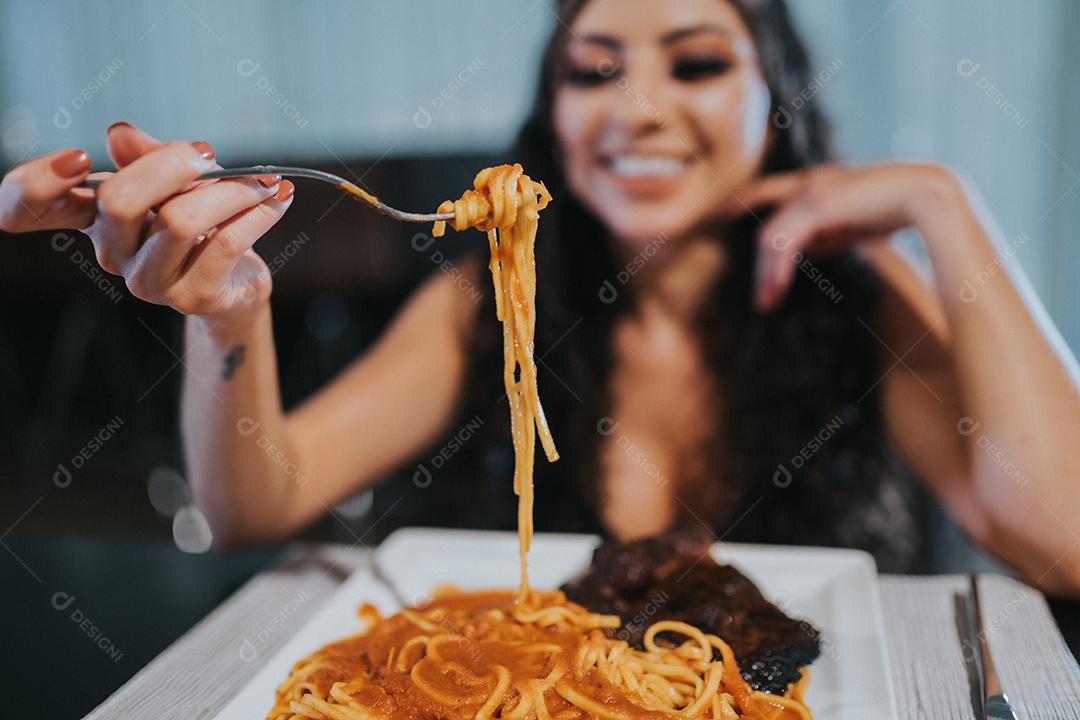 Mulher jantando a noite em restaurante. Jovem linda