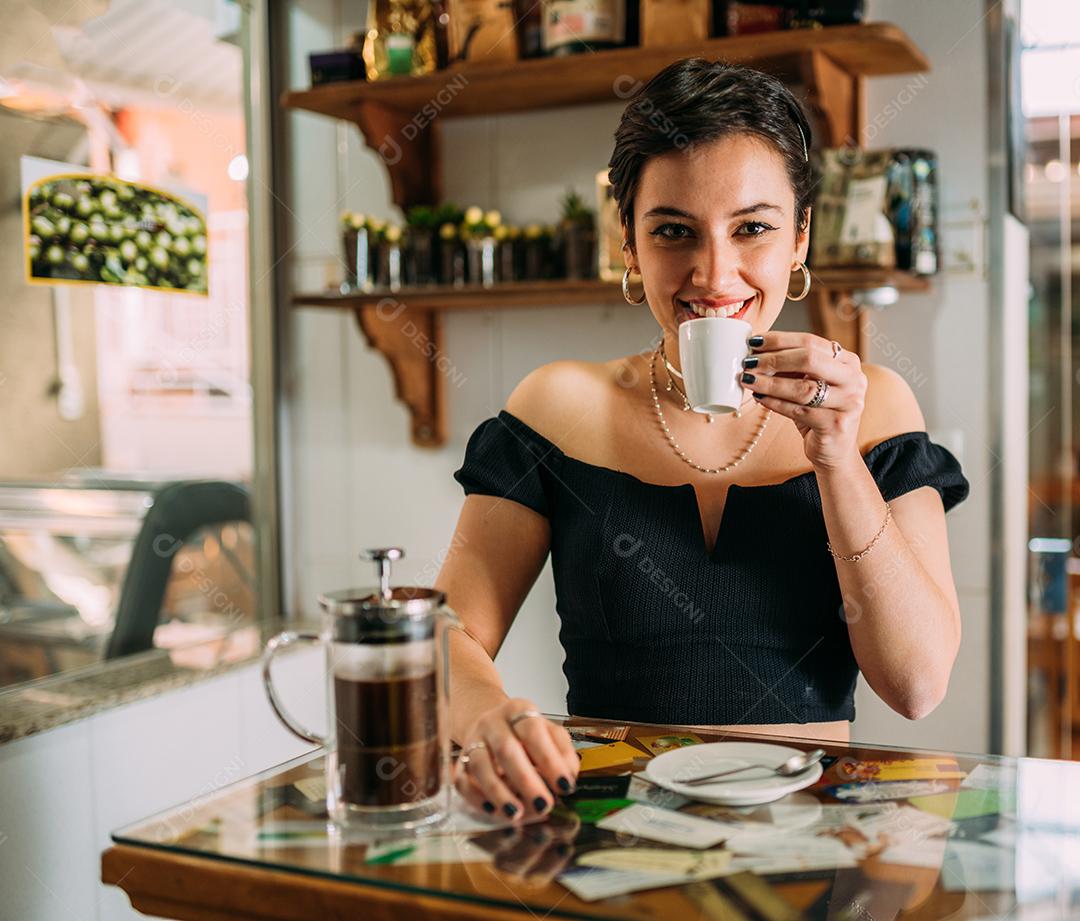 Jovem linda mulher latina feliz desfrutando café em uma rua