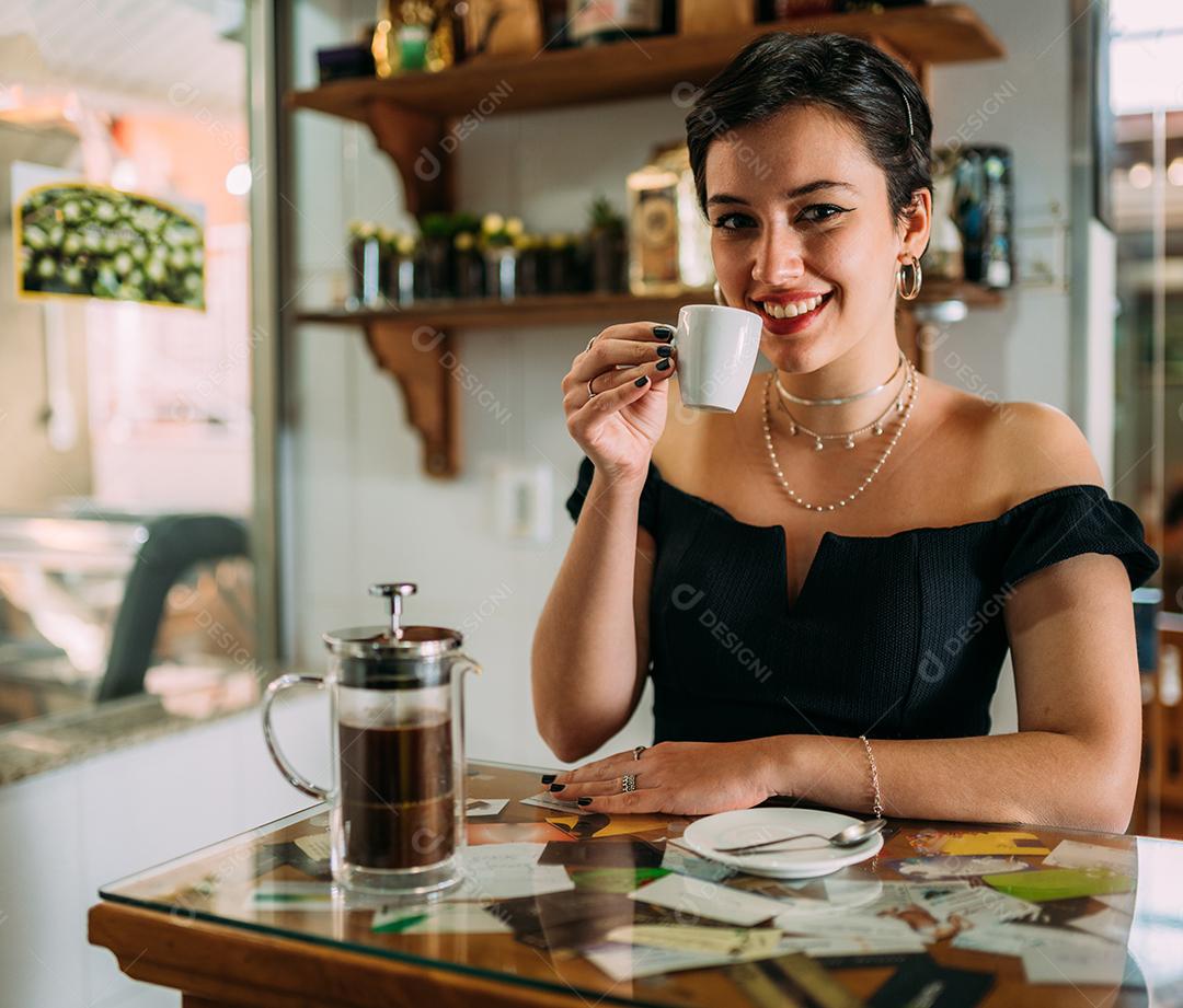 Jovem linda mulher latina feliz desfrutando café em uma rua