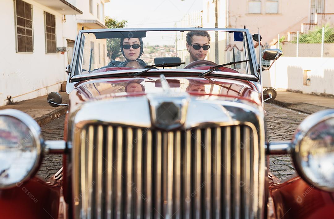 Amigos viajando juntos em um velho carro conversível. Verão