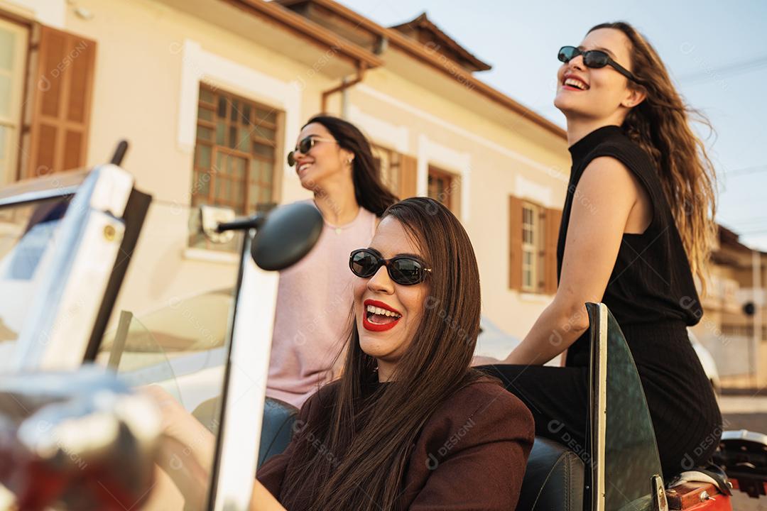 Amigos viajando juntos em um velho carro conversível. Verão