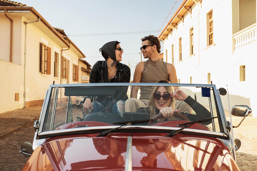 Amigos viajando juntos em um velho carro conversível. Verão