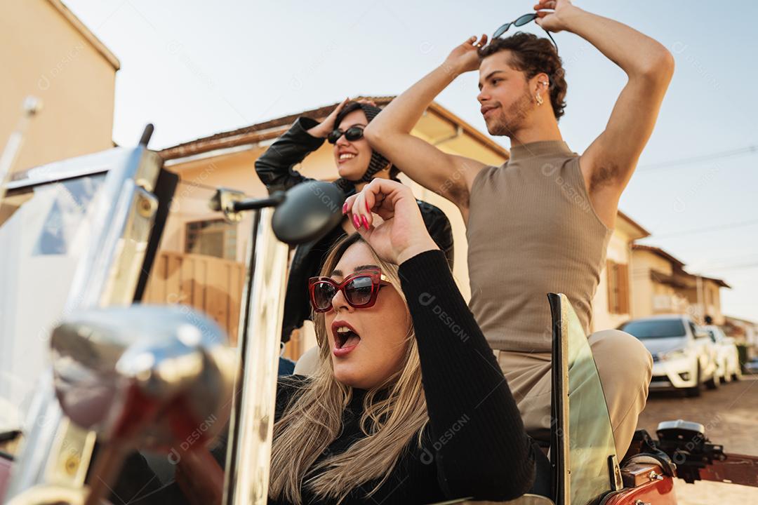 Amigos viajando juntos em um velho carro conversível. Verão