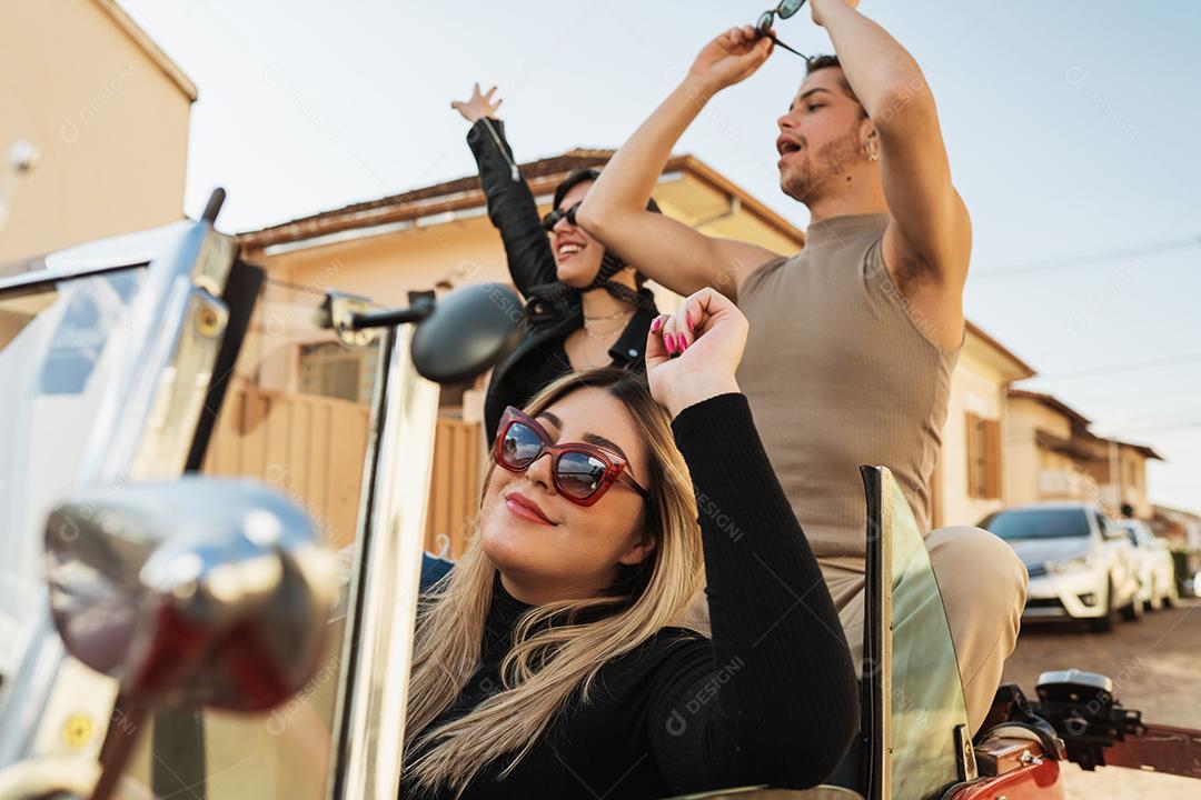 Amigos viajando juntos em um velho carro conversível. Verão