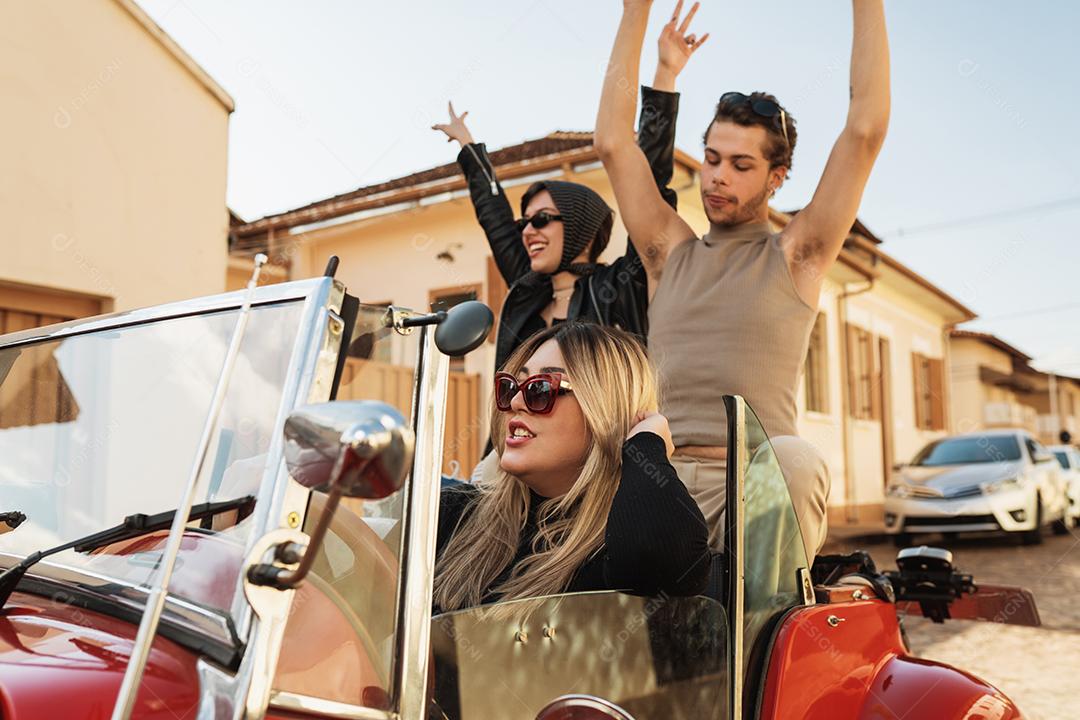 Amigos viajando juntos em um velho carro conversível. Verão