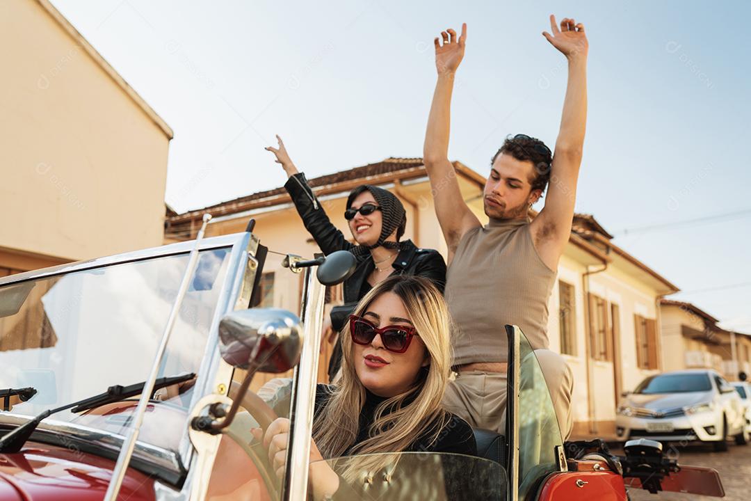 Amigos viajando juntos em um velho carro conversível. Verão