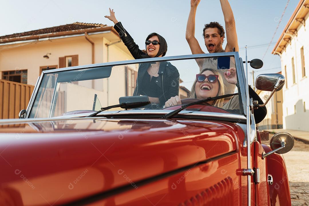 Amigos viajando juntos em um velho carro conversível. Verão