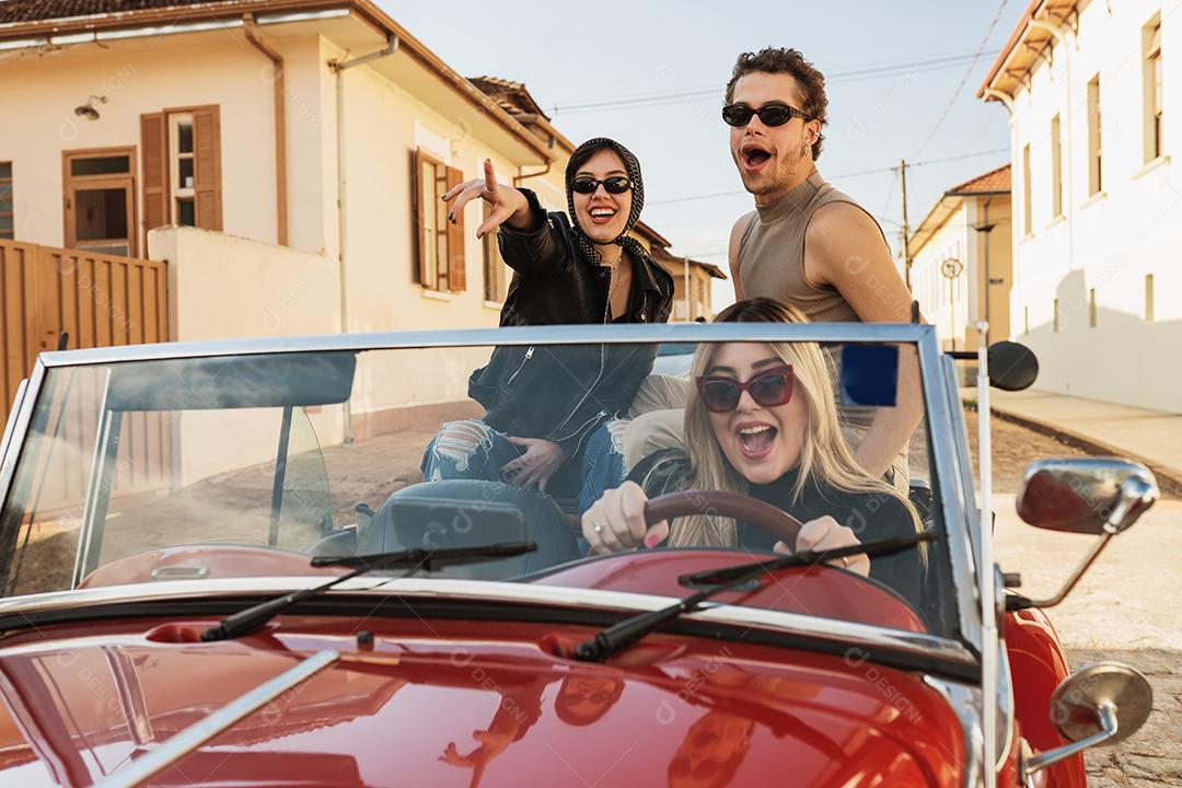 Amigos viajando juntos em um velho carro conversível. Verão
