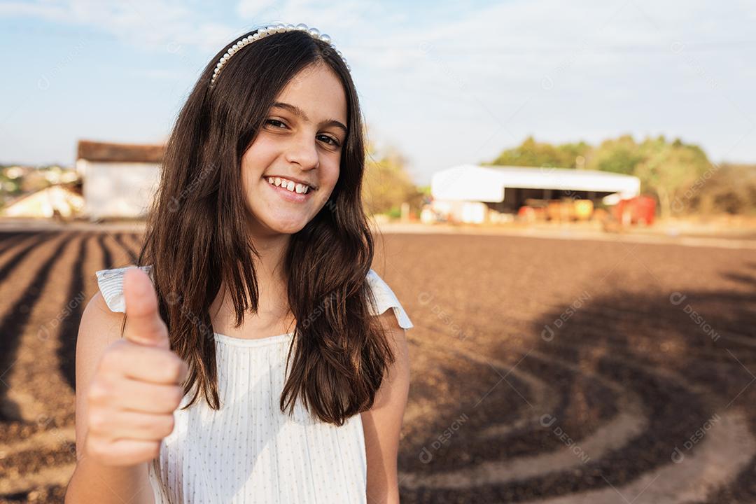 Feliz menina criança bonita no fundo da fazenda de café.