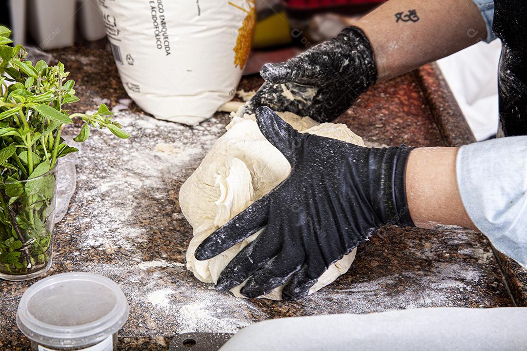 Pessoa emaçando a massa da pizza comida pizzarias