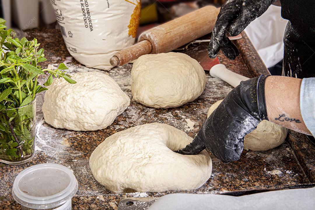 Pessoa emaçando a massa da pizza comida pizzarias