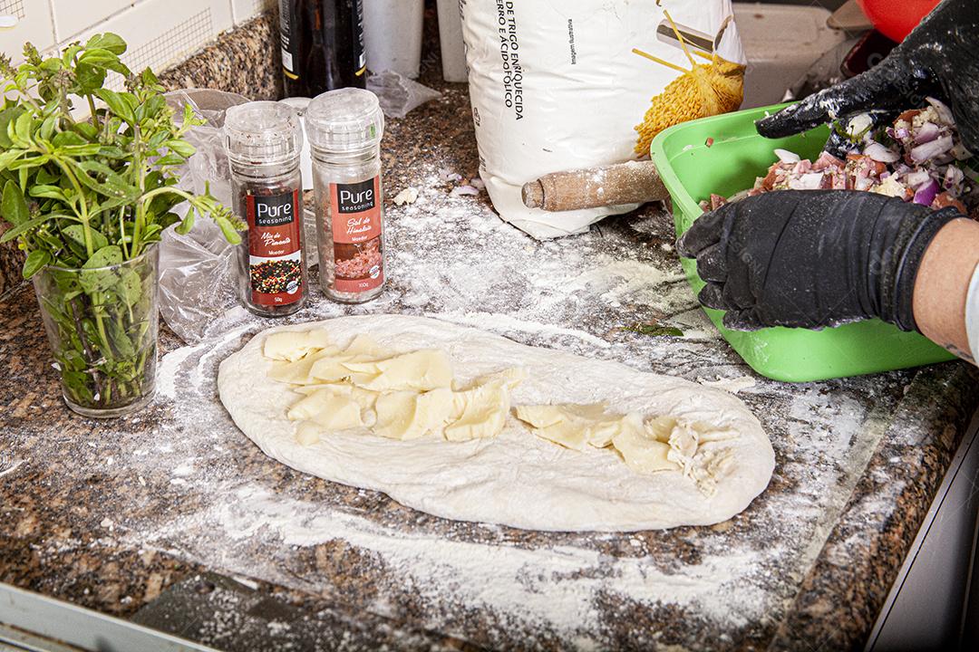 Pessoa emaçando a massa da pizza comida pizzarias