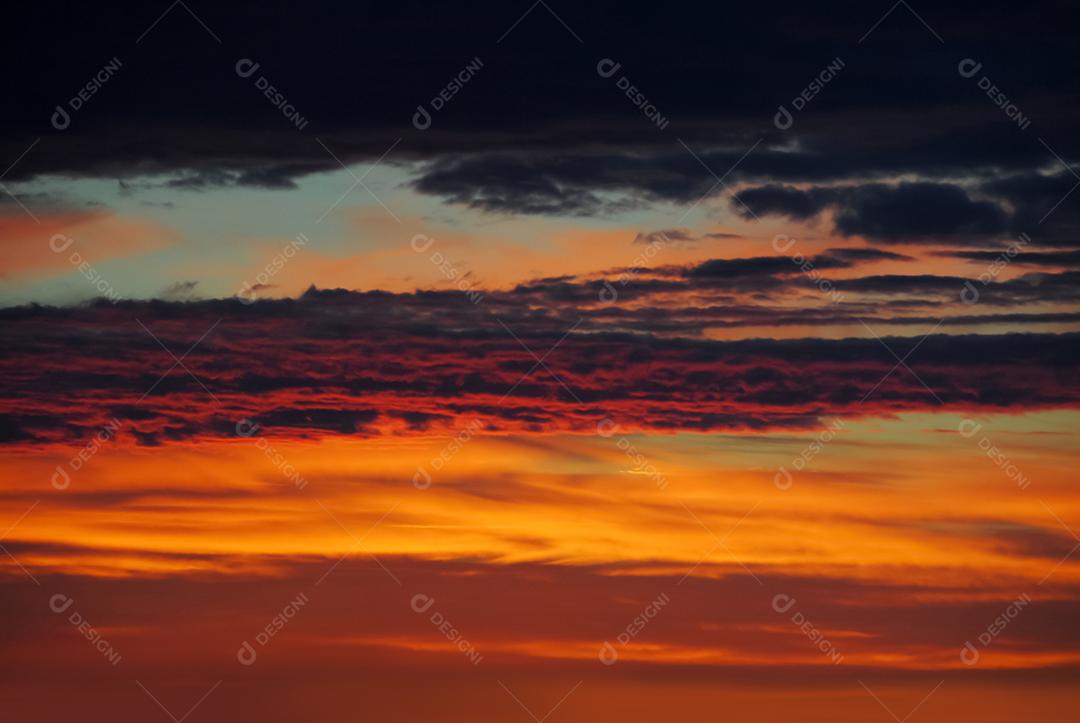 Céu rosado com nuvens rajadas ao anoitecer. Paisagem.