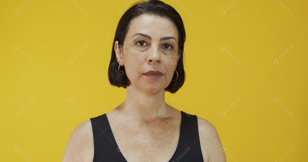 Mulher de meia idade atraente com belo sorriso na parede amarela. Mulher muito mais velha, confiança bem sucedida.