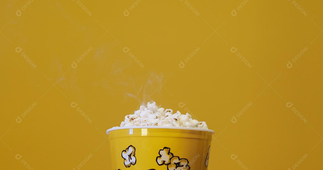 Caixa de pipoca em fundo amarelo.