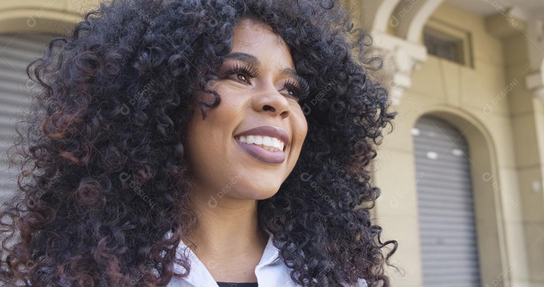 Mulher afro-americana de beleza olhando para o horizonte. Mulher bonita com cabelos cacheados se sentindo