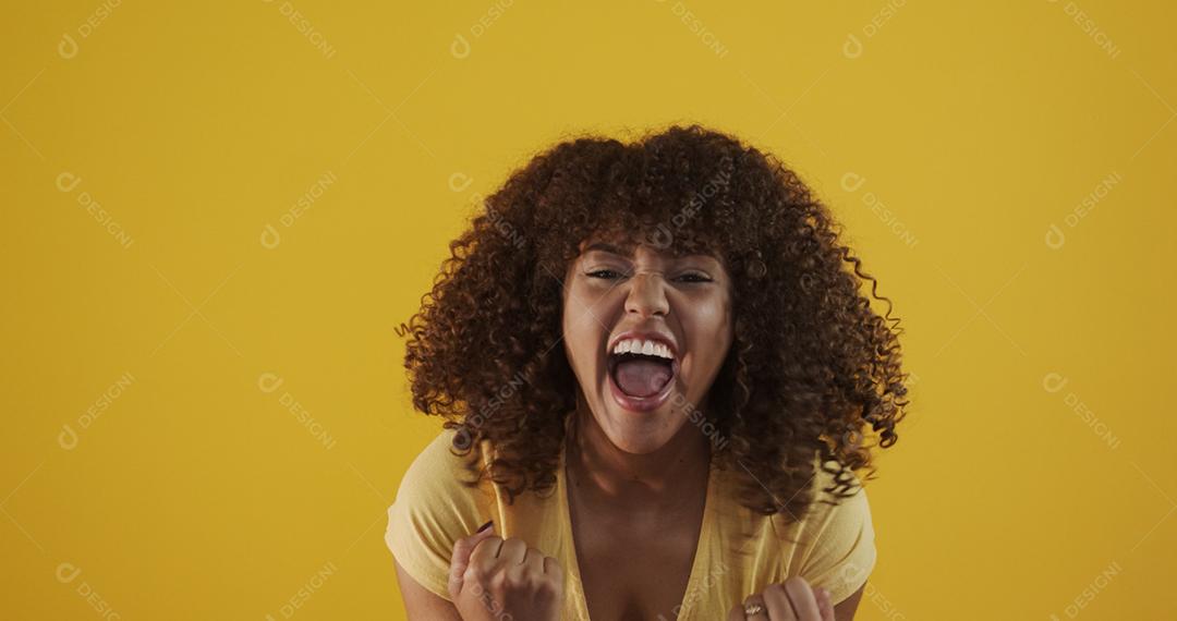 Feliz rindo mulher africana americana com seu cabelo encaracolado em fundo amarelo. Rindo mulher encaracolada