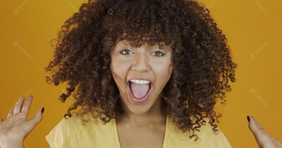 Linda modelo morena sorrindo para a câmera. Dentes bonitos. Cabelo encaracolado. jovem brasileira.