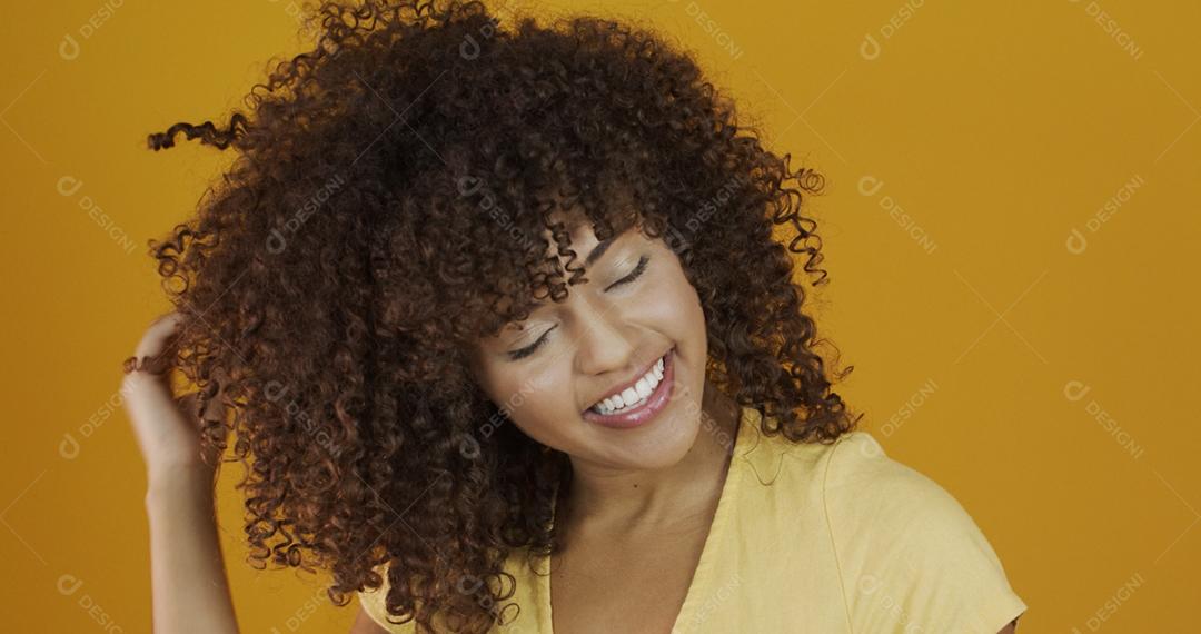Linda modelo morena sorrindo para a câmera. Dentes bonitos. Cabelo encaracolado. jovem brasileira.