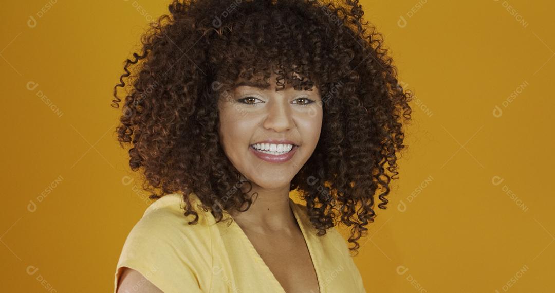 Linda modelo morena sorrindo para a câmera. Dentes bonitos. Cabelo encaracolado. jovem brasileira.