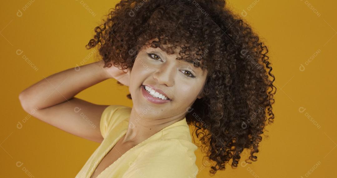 Feliz rindo mulher africana americana com seu cabelo encaracolado em fundo amarelo. Rindo mulher encaracolada .
