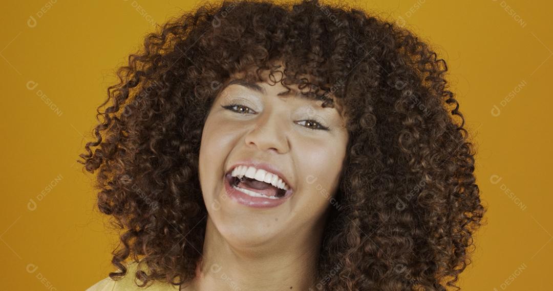Linda modelo morena sorrindo para a câmera. Dentes bonitos. Cabelo encaracolado. jovem brasileira.