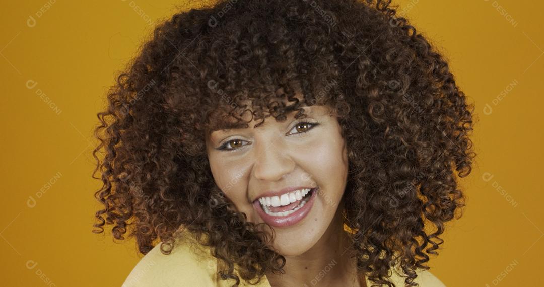 Linda modelo morena sorrindo para a câmera. Dentes bonitos. Cabelo encaracolado. jovem brasileira.