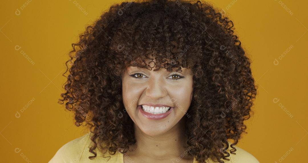 Linda modelo morena sorrindo para a câmera. Dentes bonitos. Cabelo encaracolado. jovem brasileira.