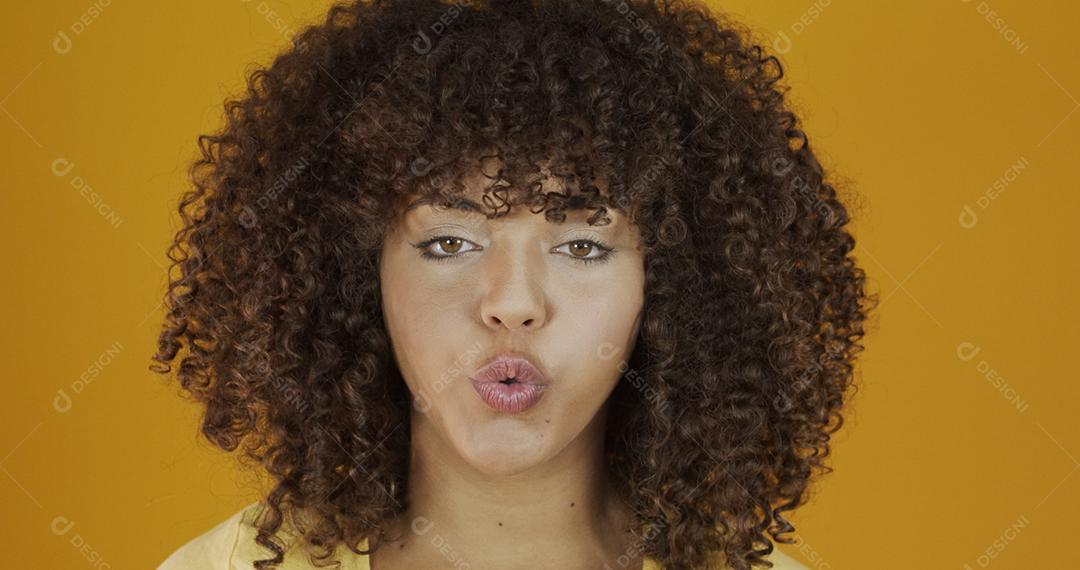 Linda modelo morena em amarelo. Cabelo encaracolado. jovem brasileira.