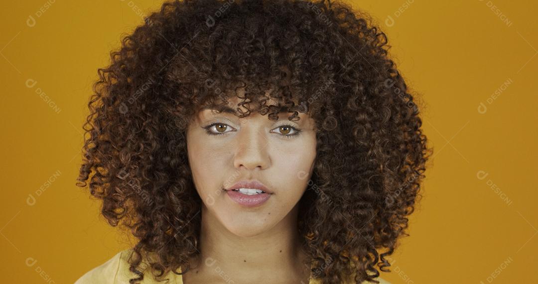 Linda modelo morena em amarelo. Cabelo encaracolado. jovem brasileira.