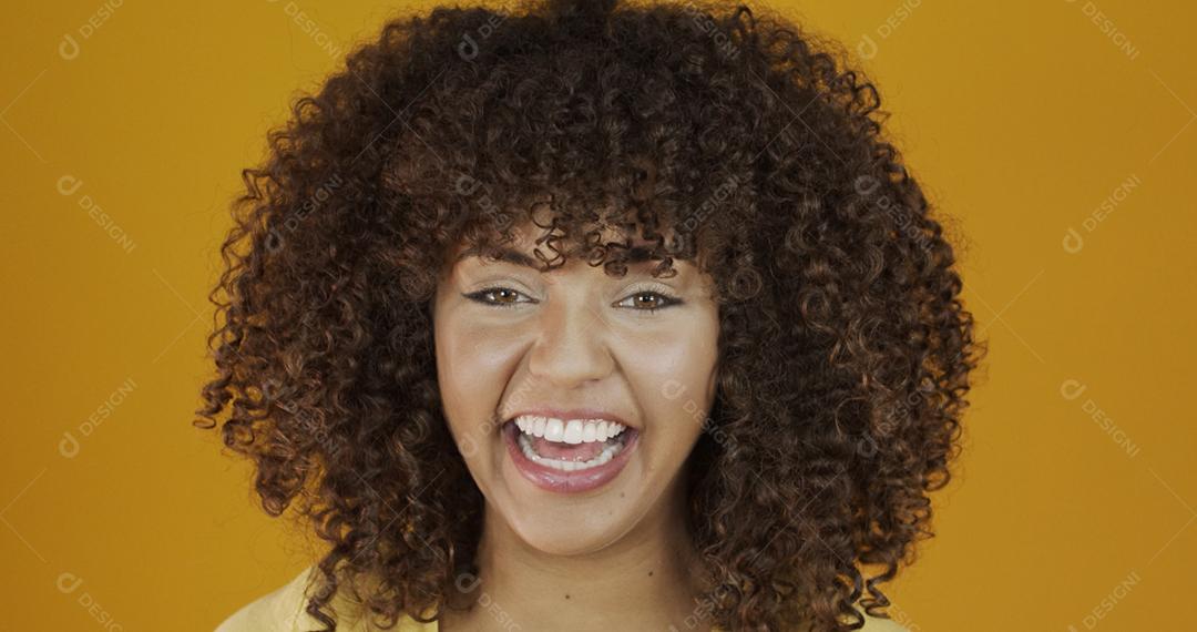 Linda modelo morena sorrindo para a câmera. Dentes bonitos. Cabelo encaracolado. jovem brasileira.