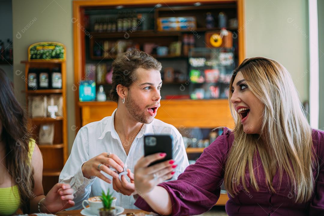 Jovem latino surpreendeu gritando amigos no café de comida de rua brilhante retrô usando telefone celular.