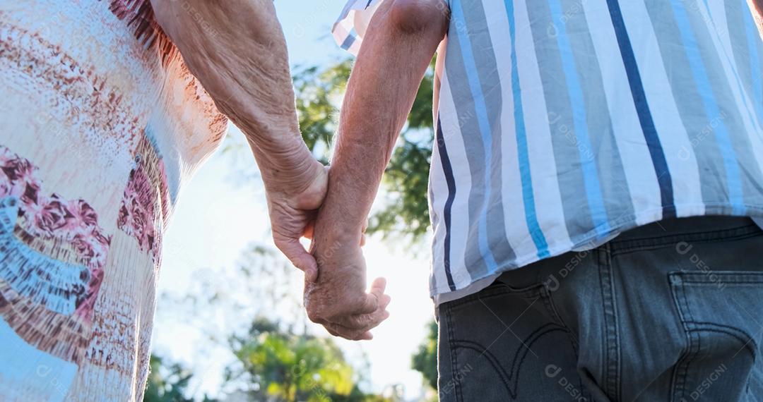 Casal de idosos de mãos dadas e close-up