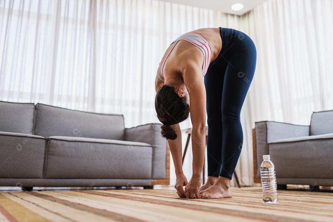 Atraente jovem latina fazendo ioga alongamento ioga em casa. Conceito de estilo de vida saudável.