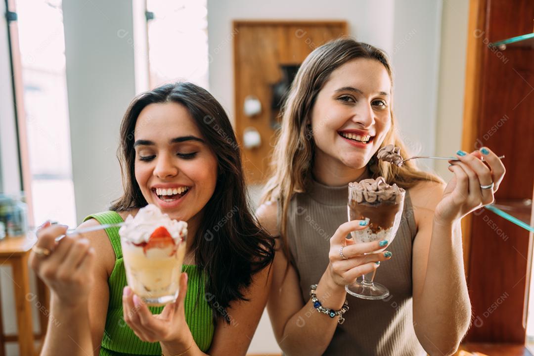 Jovens garotas latinas sentadas no café