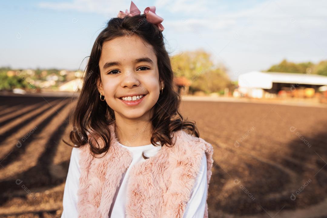 Menina criança bonita feliz no fundo da fazenda de café. Garoto na fazenda. Povo latino.