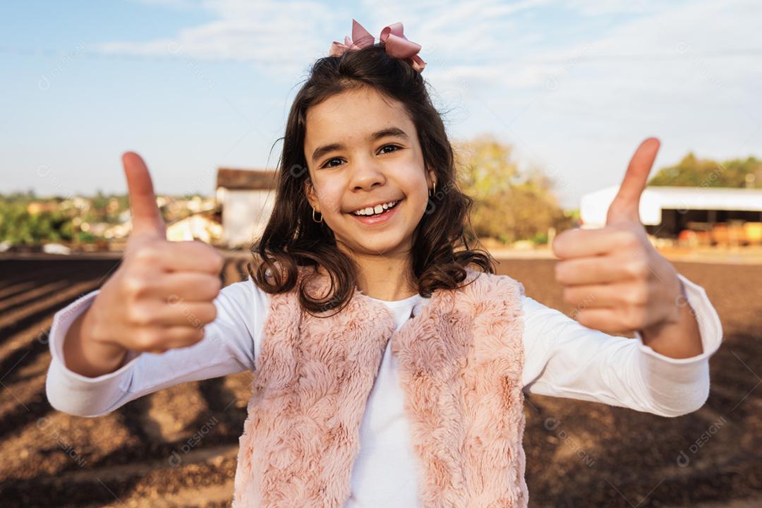 Menina criança bonita feliz no fundo da fazenda de café. Garoto na fazenda. Povo latino.