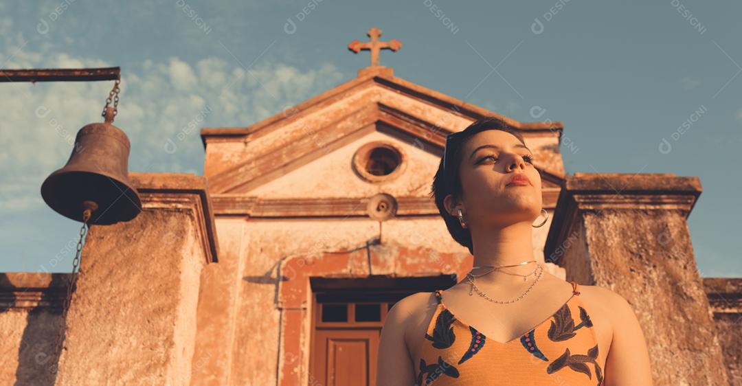 Retrato de uma jovem latina elegante e elegante em frente a uma pequena capela