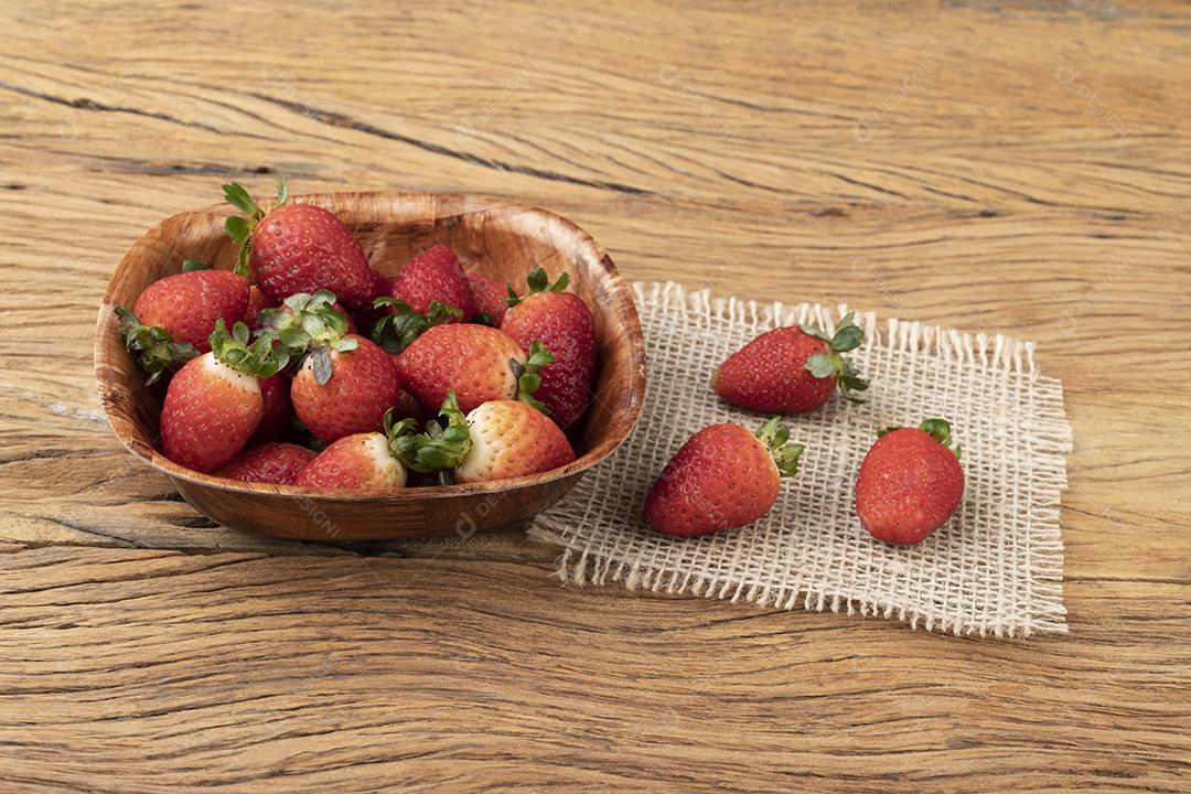 Morangos em uma tigela sobre mesa de madeira