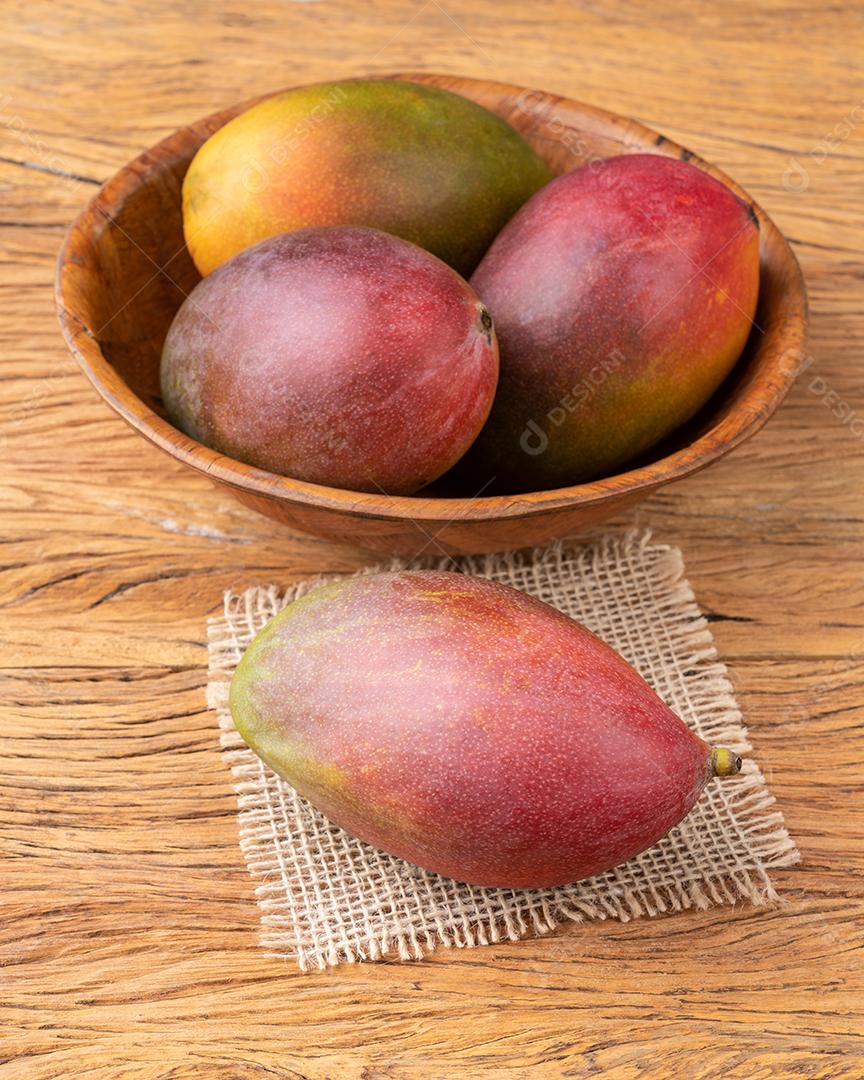 Um grupo de mangas maduras sobre a mesa de madeira