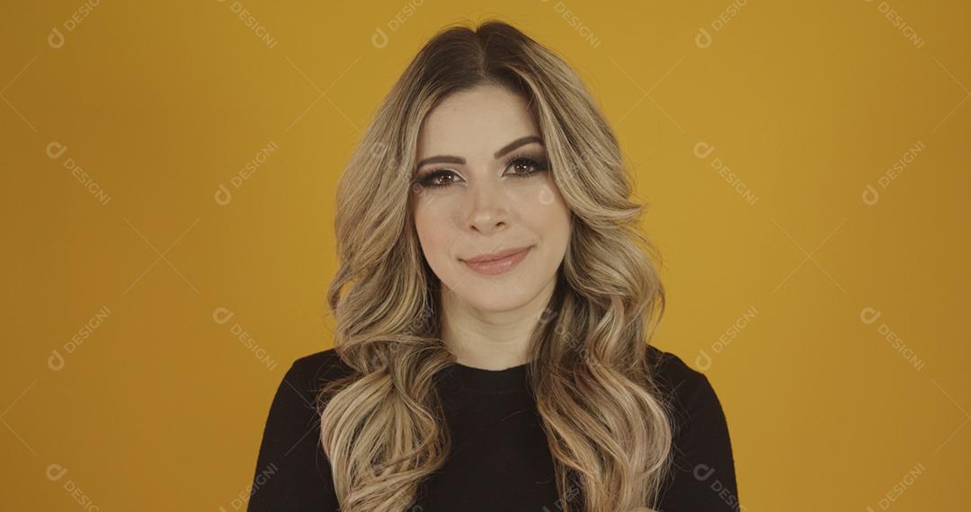 Jovem linda loira caucasiana feliz. Conceito de sucesso e realização. Alegre mulher loira bonita sobre fundo amarelo.