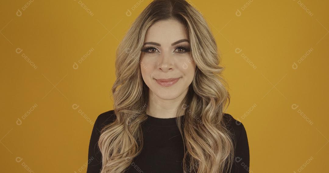 Jovem linda loira caucasiana feliz. Conceito de sucesso e realização. Alegre mulher loira bonita sobre fundo amarelo.