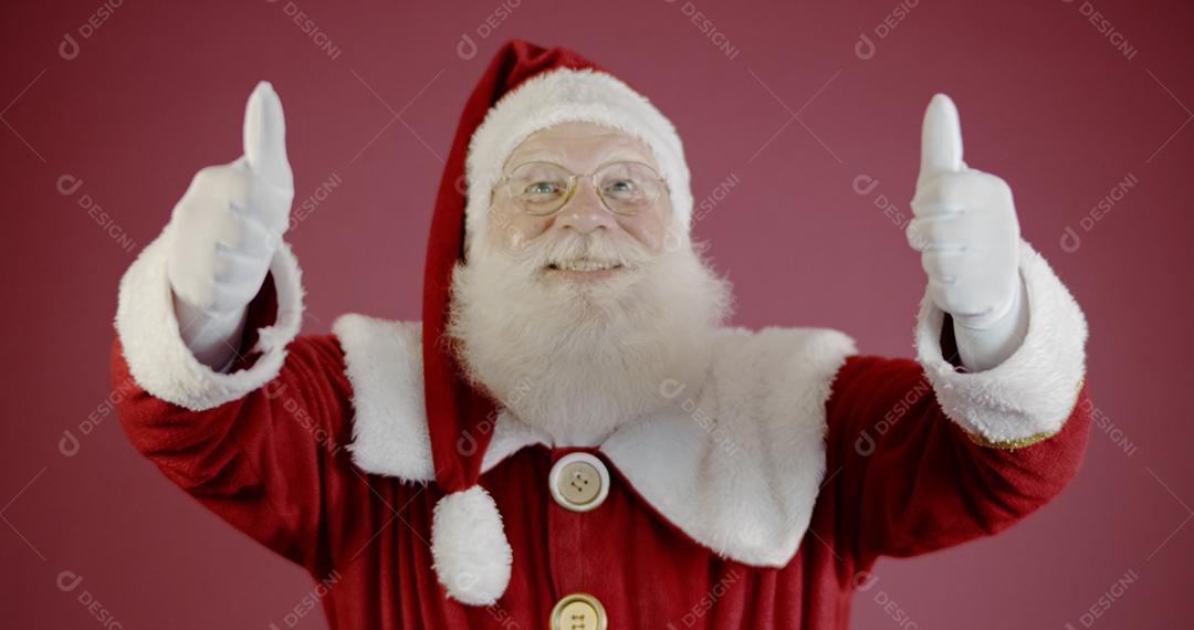 Papai Noel mostrando o polegar para cima. Papai Noel com barba de verdade e grande sorriso dando o polegar para cima.