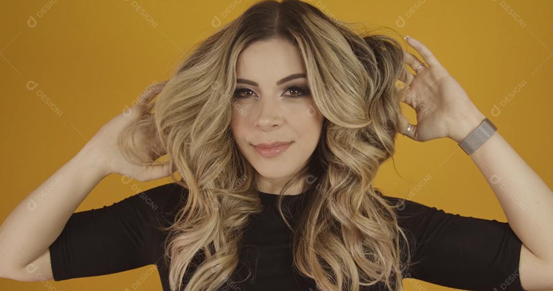 Jovem linda loira caucasiana feliz. Conceito de sucesso e realização. Alegre mulher loira bonita sobre fundo amarelo.