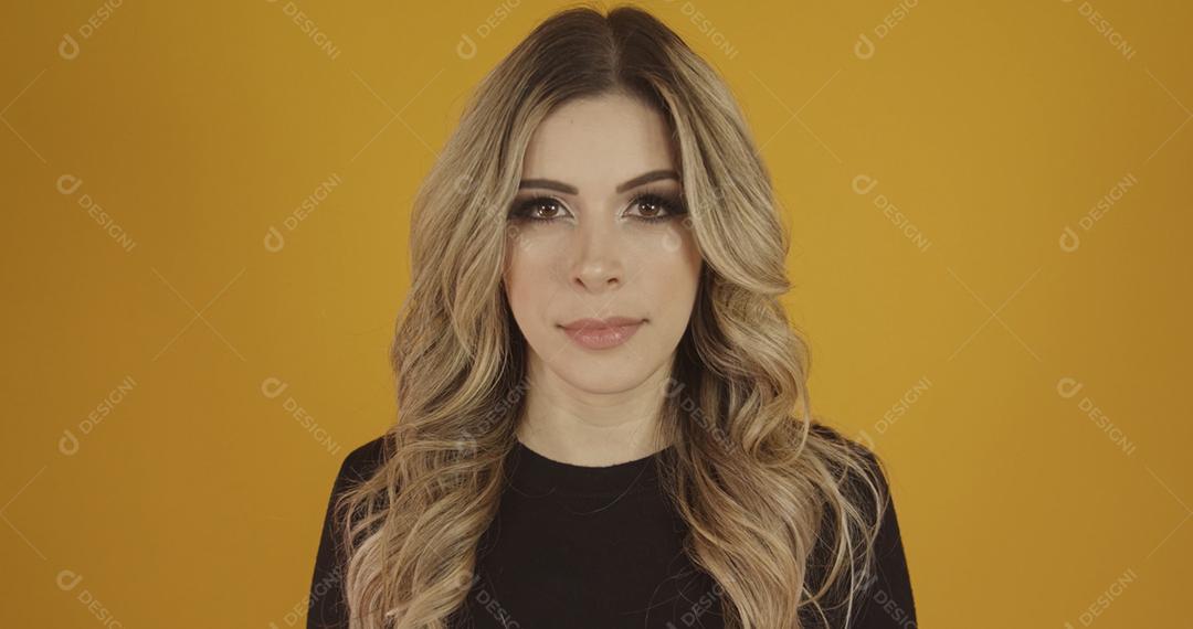 Jovem linda loira caucasiana feliz. Conceito de sucesso e realização. Alegre mulher loira bonita sobre fundo amarelo.